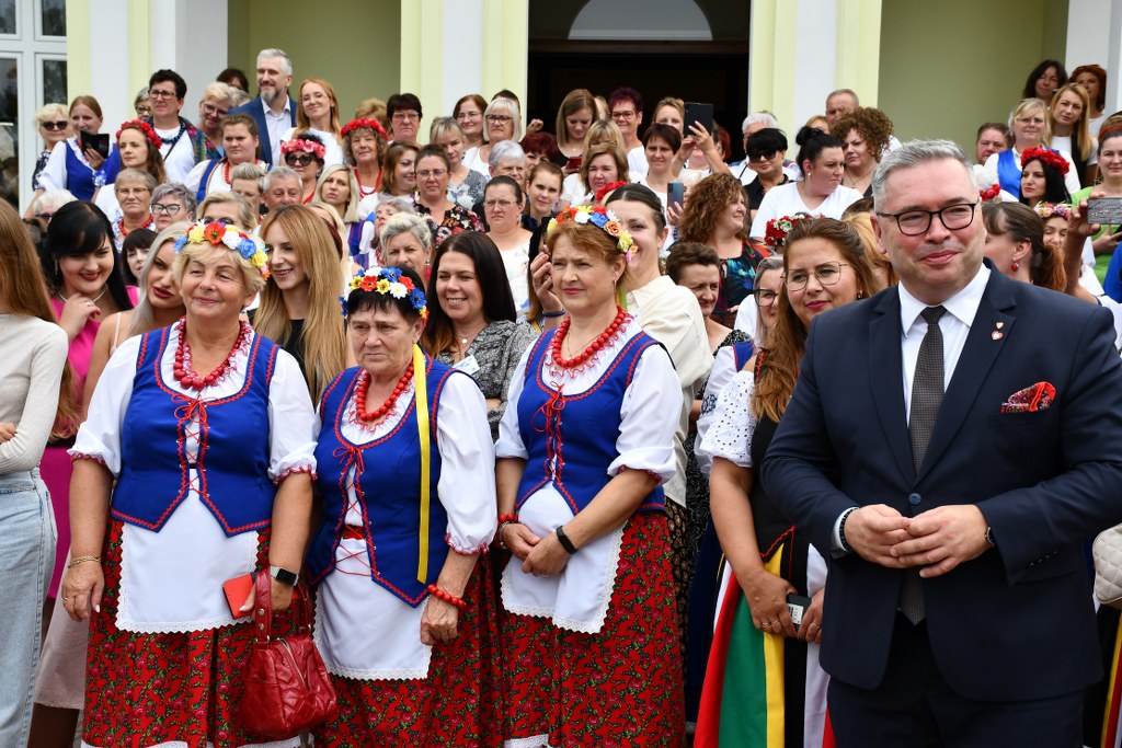 grupa pań i panów przed pałacem